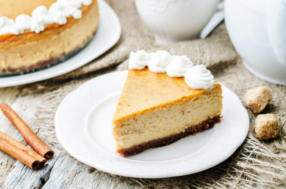 pumpkin cheesecake decorated with whipped cream.