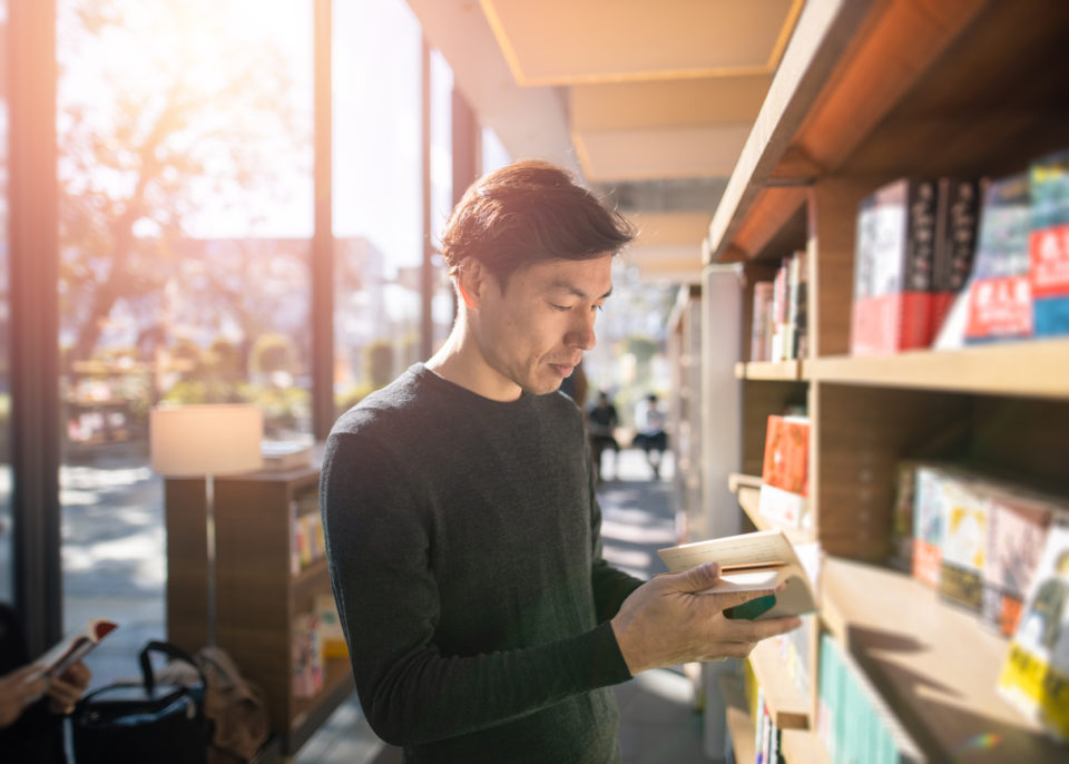 man reading book at library