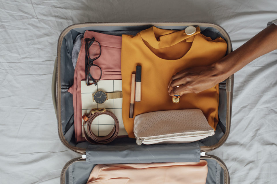 A Woman Packing her Clothes in a Suitcase