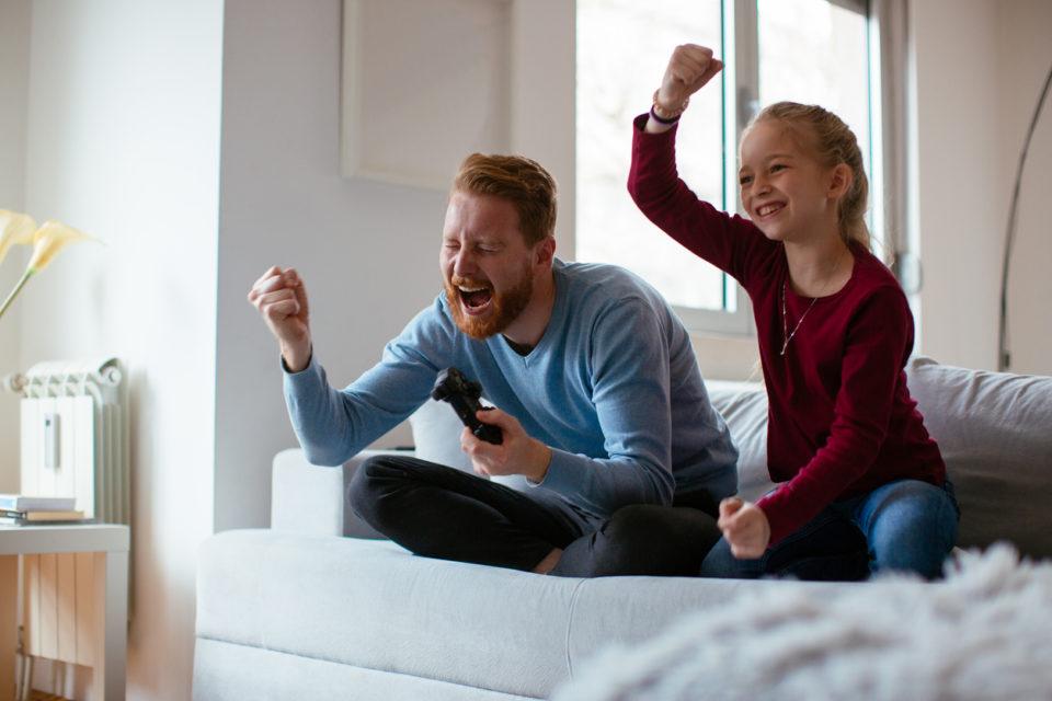 Dad and daughter playing video games